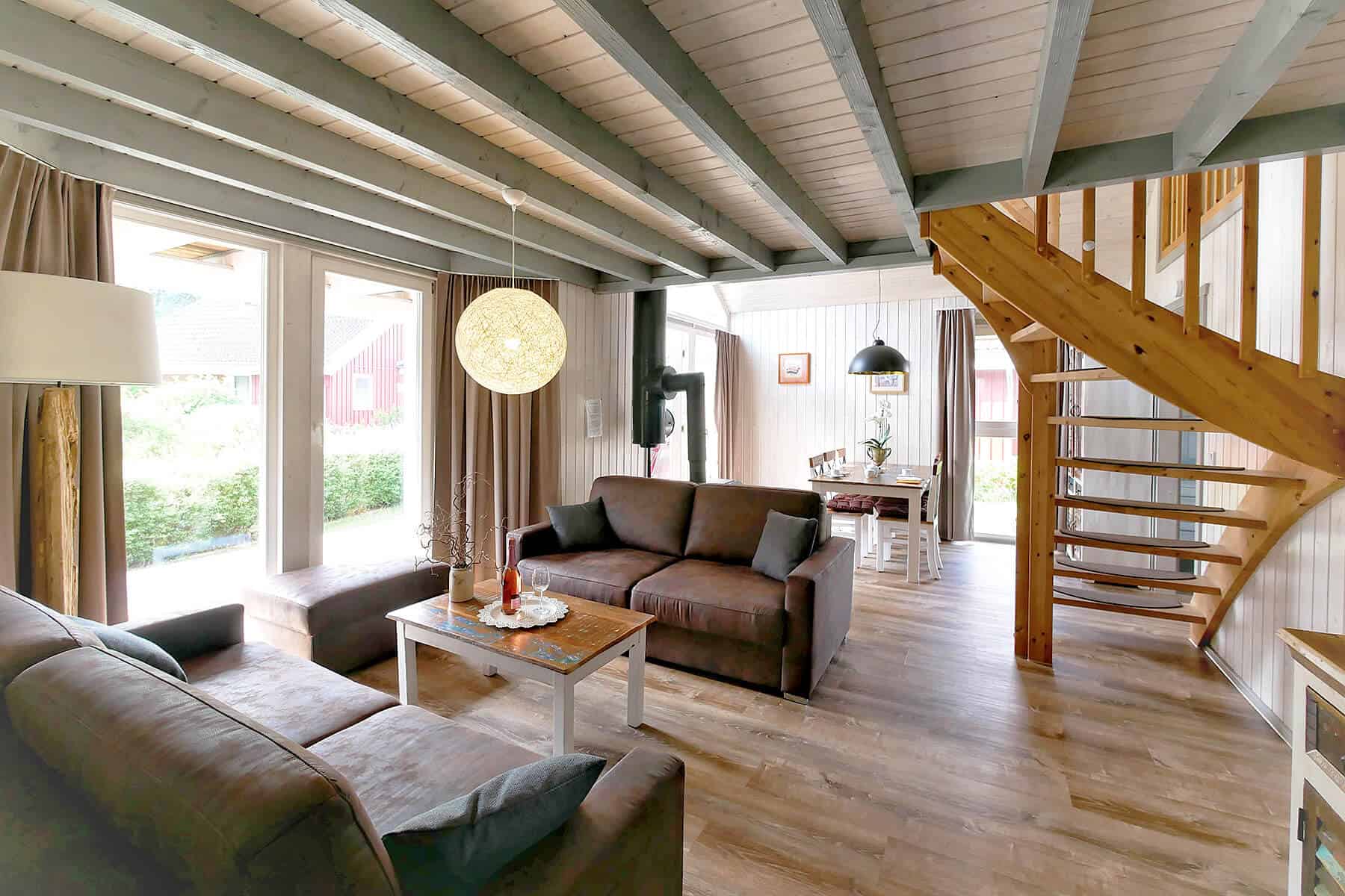 Ferienhaus Seeperle XL in Wendisch Rietz. Ansicht des Wohnbereiches im Erdgeschoss mit Esstisch und Couch.