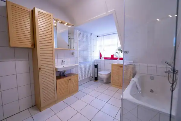 Bad, links Waschtisch, Mitte WC, rechts Badewanne und Dusche