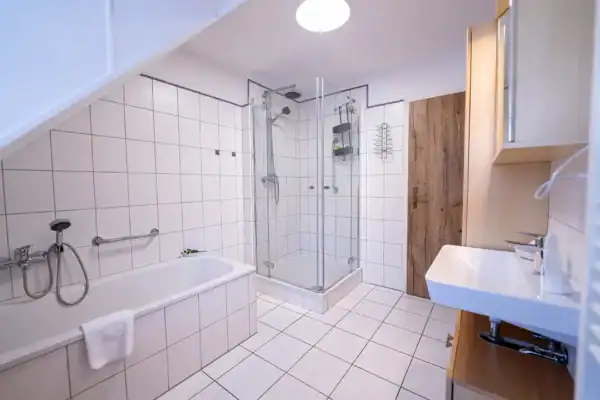 Bad, links Badewanne, Mitte hinten Dusche, rechts Waschtisch