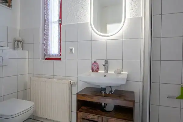 Bad, links WC, Mitte Waschtisch mit Spiegel, rechts Dusche