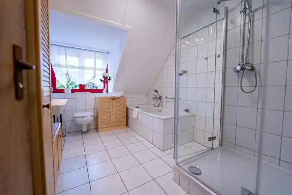 Blick ins Bad, rechts Dusche, hinten Badewanne und WC