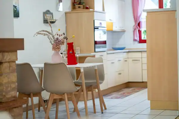 Blick in Richtung Küche, vorne Tisch und Stühle, hinten Küchenzeile